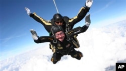 FILE - Former President George H.W. Bush during free fall with U.S. Army Golden Knights parachute team member, Sgt. 1st Class Mike Elliott, College Station, Texas, Nov. 2007.