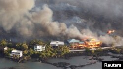 Lava destroys homes in the Kapoho area, east of Pahoa, during ongoing eruptions of the Kilauea volcano in Hawaii, June 5, 2018.