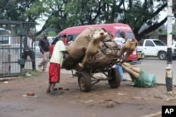 FILE: A man prepares to transport manikins to a market shop in downtown Harare, in this Monday, Dec.10 , 2018 photo.