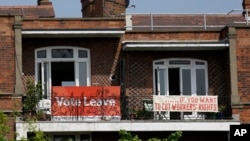 FILE - Banners of opposing views on Britain's so-called Brexit referendum on EU membership are displayed on the balconies of two neighboring apartments in the Gospel Oak area of north London, May 27, 2016.