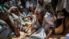 FILE - An Ethiopian woman argues with others over the allocation of yellow split peas after it was distributed by the Relief Society of Tigray in the town of Agula, in the Tigray region of northern Ethiopia, on Saturday, May 8, 2021.