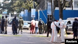Ugandan police and explosion experts secure the scene of a blast in Kampala, Uganda, Nov. 16, 2021. 