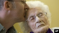 Besse Cooper receives a kiss from her grandson during a Guinness World Records ceremony in Monroe, Ga, March 10, 2011. 