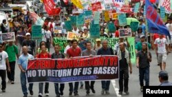 Protesters display placards and banners as they march towards the gates of the U.S. Embassy during a protest in Manila, July 4, 2013. 