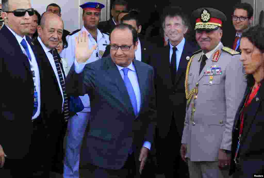 Presiden Perancis Francois Hollande melambaikan tangan ketika tiba di acara pembukaan Terusan Suez Baru di Ismailia, Mesir, 6 Agustus 2015.