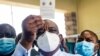 File - In this February 18, 2021 photo, Zimbabwe vice president and Minister of Health Constantino Chiwenga holds up his vaccination certificate after receiving the first shot of Sinopharm COVID-19 vaccine from China.