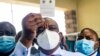 Zimbabwe vice president and Minister of Health Constantino Chiwenga holds up his vaccination certificate after receiving the first shot of Sinopharm in the southern African country which received a donation of 200 000 doses of the COVID-19 vaccine from Ch
