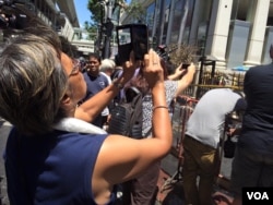 People take "selfies" in front of the Erawan Shrine, location of a bomb blast in central Bangkok, Thailand, Aug. 18, 2015. (Photo: Steve Herman / VOA)