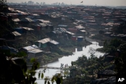 FILE - Rohingya Muslim children, who crossed over from Myanmar into Bangladesh, play on a bridge made by bamboos at Kutupalong refugee camp in Ukhiya, Bangladesh, Dec. 21, 2017.