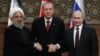 FILE - Iran's President Hassan Rouhani, from left, Turkey's President Recep Tayyip Erdogan and Russia's President Vladimir Putin shake hands after a joint press conference as part of a tripartite summit on Syria, in Ankara, April 4, 2018.