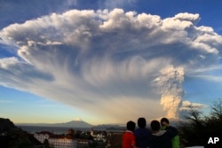 Children watch the Calbuco volcano erupt, from Puerto Varas, Chile, April 22, 2015.