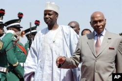 Le président sénégalais Abdoulaye Wade et le minsitre d'Etat niian aux Affaires étrangères, Aliyu Idi Hong, à l'aéroport d'Abuja