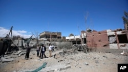 FILE - Yemeni people inspect the damage after an airstrike by Saudi-led coalition in Sana'a, Yemen, Saturday, Feb. 27, 2016. 