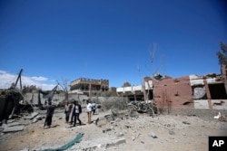 FILE - Yemeni people inspect the damage after an airstrike by Saudi-led coalition in Sana'a, Yemen, Saturday, Feb. 27, 2016.