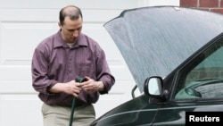 Everett Dutschke works on his mini-van in his driveway in Tupelo, Mississippi, Apr. 26, 2013. 