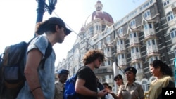 Police stop foreign tourists to check their belongings at a security checkpoint outside the Taj Mahal Palace hotel in Mumbai 24 Dec, 2010. Police have launched a manhunt for four men they said belonged to a Pakistan-based militant group and had entered M