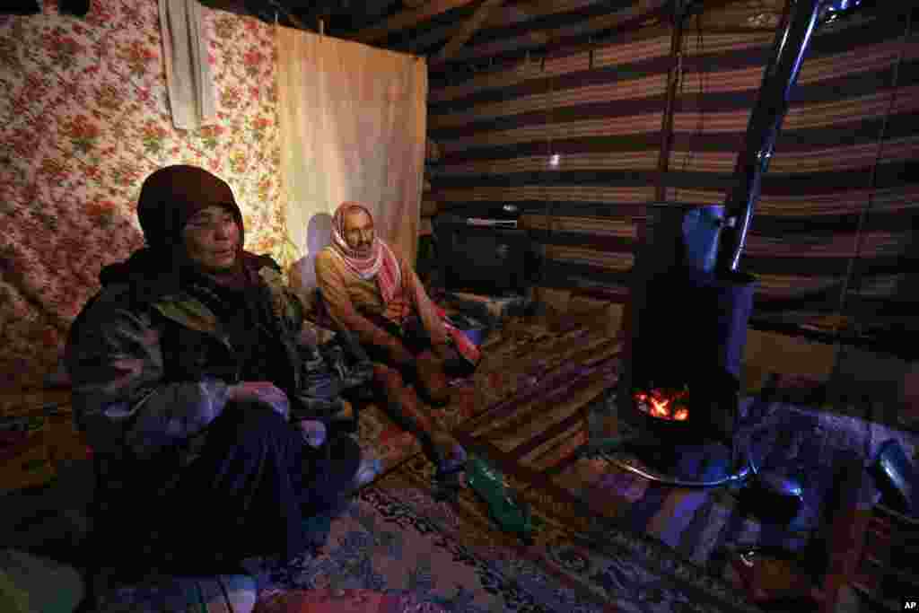 Syrian refugees sit inside their tent at a refugee camp near Baalbek, Lebanon, Dec. 15, 2013.
