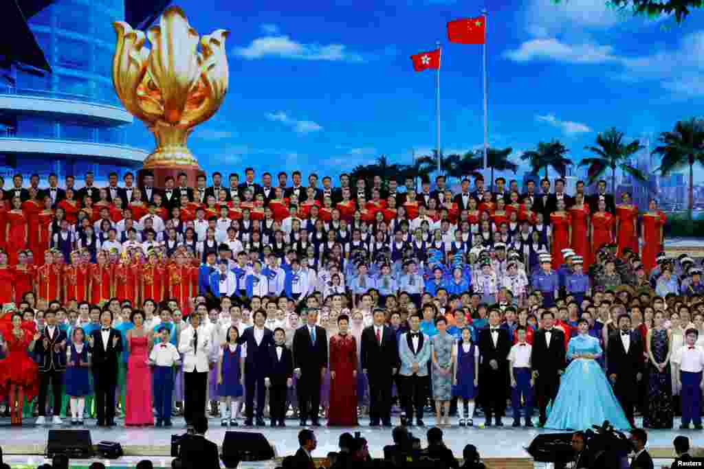 在维多利亚港的香港会展中心举行的庆祝香港主权移交中国20周年的文艺晚会上，中国最高领导人习近平以及香港特首梁振英和当选特首林郑月娥等人和演员们一起歌唱（2017年6月30日）。