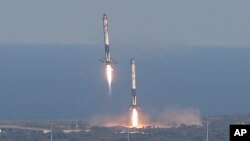 Eight minutes after liftoff, SpaceX lands two of the first-stage boosters side by side at the Kennedy Space Center in Cape Canaveral, Fla., April 11, 2019.