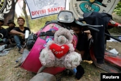 FILE - A stuffed toy mascot is tied to the front of a modified Vespa at a weekend festival for extreme Vespas in Semarang, Central Java, Indonesia, July 22, 2018.