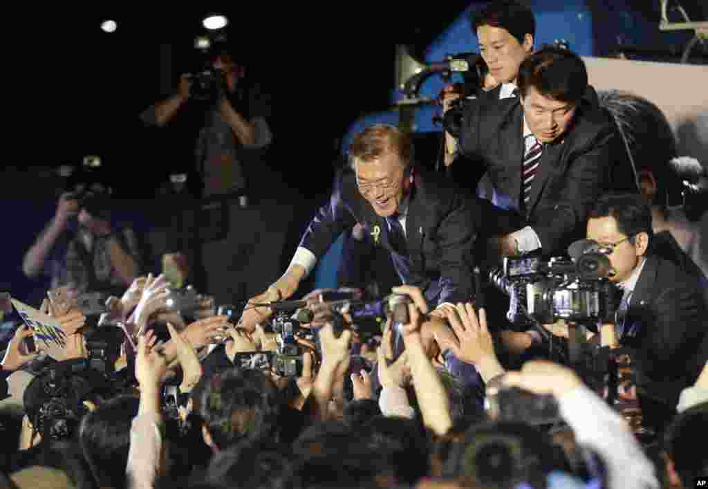 South Korea&#39;s presidential candidate Moon Jae-in of the Democratic Party is greeted by supporters as he arrives to give a speech on a stage in Seoul. Moon declared victory in the country&#39;s presidential election, setting up its first liberal rule in a decade.