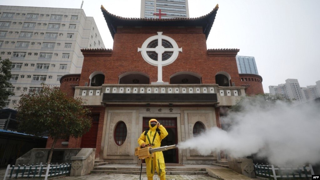 一名工人在武汉汉口教堂救世堂前为防疫新冠病毒喷洒消毒药水。（2020年3月6日）