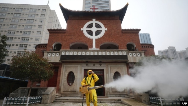一名工人在武漢漢口教堂救世堂前為防疫新冠病毒噴洒消毒藥水。（2020年3月6日）