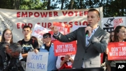 Pendiri "Let America Vote" berbicara kepada demonstran di luar Saint Anselm College di Manchester, di mana Komisi Penyelidikan Penipuan Surat Suara pemerintahan Trump mengadakan pertemuan, 12 September 2017. Komisi ini telah dibubarkan.