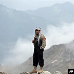 An Afghan security man stands near the mountains where an Afghan Pamir Airways plane is believed to have crashed in the Salang pass, north of Kabul, 17 May 2010