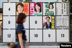 A woman walks past candidates' posters for the October 22 lower house election in Tokyo, Japan, Oct. 10, 2017.