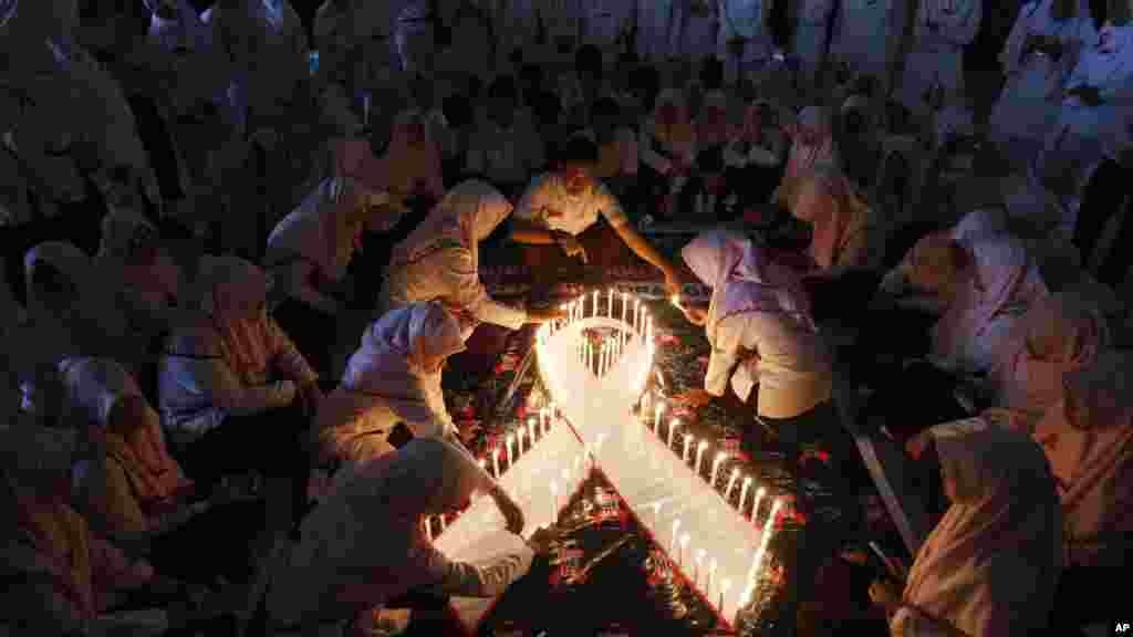 Des bougies allumées par des étudiants indonésiens en médecine lors d&#39;une veillée à l&rsquo;occasion organisée de la journée mondiale de lutte contre le sida à Surabaya, Java-Est, Indonésie, 1er décembre 2015.&nbsp;