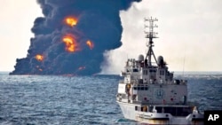 In this photo provided by China's Ministry of Transport, a rescue ship sails near the burning Iranian oil tanker Sanchi in the East China Sea off the eastern coast of China, Jan. 14, 2018.