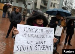 FILE - A woman holds a banner supporting the South Stream project during a demonstration in Varna, Bulgaria, March 26, 2018.