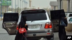 Saudi women get out of the backseats of a car in Riyadh on June 17, 2011