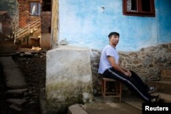 FILE - Bulgarian Roma man Georgi Petrov poses for a picture in front of his house in the village of Vrachesh, Jan. 21, 2015.