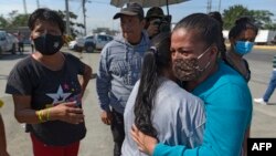 유혈 충돌이 벌어진 에콰도르 과야킬의 교도소 앞에서 29일 재소자 가족들이 끌어안고 있다.