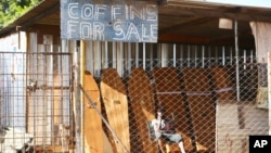 A worker at a coffin making company waits for clients inside the company premises in Harare, Tuesday, Jan. 5, 2021, as Zimbabwe has began a 30-day lockdown in a bid to rein in the spike in COVID -19 infections threatening to overwhelm health services.