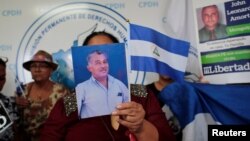 A woman holds a picture during a news conference at the Permanent Commission of Human Rights of Nicaragua (CPDH) headquarters to demand the release of the demonstrators detained during last year's protests.