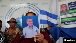 FILE - A woman holds a picture during a news conference at the Permanent Commission of Human Rights of Nicaragua headquarters to demand the release of the demonstrators detained during protests against Nicaraguan President Daniel Ortega's government in Managua, April 26, 2019.