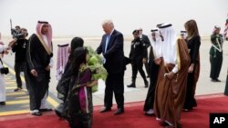 Rais Donald Trump na mkewe Melania Trump wakilakiwa na Mfalme Salman mara baada ya kuwasili Saudi Arabia