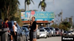 FILE - Local residents wait for the reopening of the entry road for the Florida Keys road after Hurricane Irma strikes Florida, in Homestead, Florida, Sept. 11, 2017. 