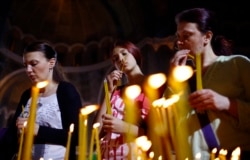 Perempuan menyalakan lilin selama kebaktian Paskah Ortodoks di Biara St. Sava di Beograd 5 Mei 2013. (Photo: REUTERS/Marko Djurica)