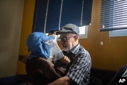 In this Wednesday, July 24, 2019 photo, Habib El Ghazaoui, a father who runs the Association for Solidarity with Children of the Moon, plays with 8 year-old Mustapha who is affected by a rare genetic disorder called xeroderma pigmentosum, or XP, inside a hospital in Casablanca, Morocco. (AP Photo/Mosa'ab Elshamy)