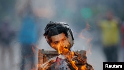 Anti-government protesters burn an effigy depicting Venezuela's President Nicolas Maduro in Caracas April 20, 2014.