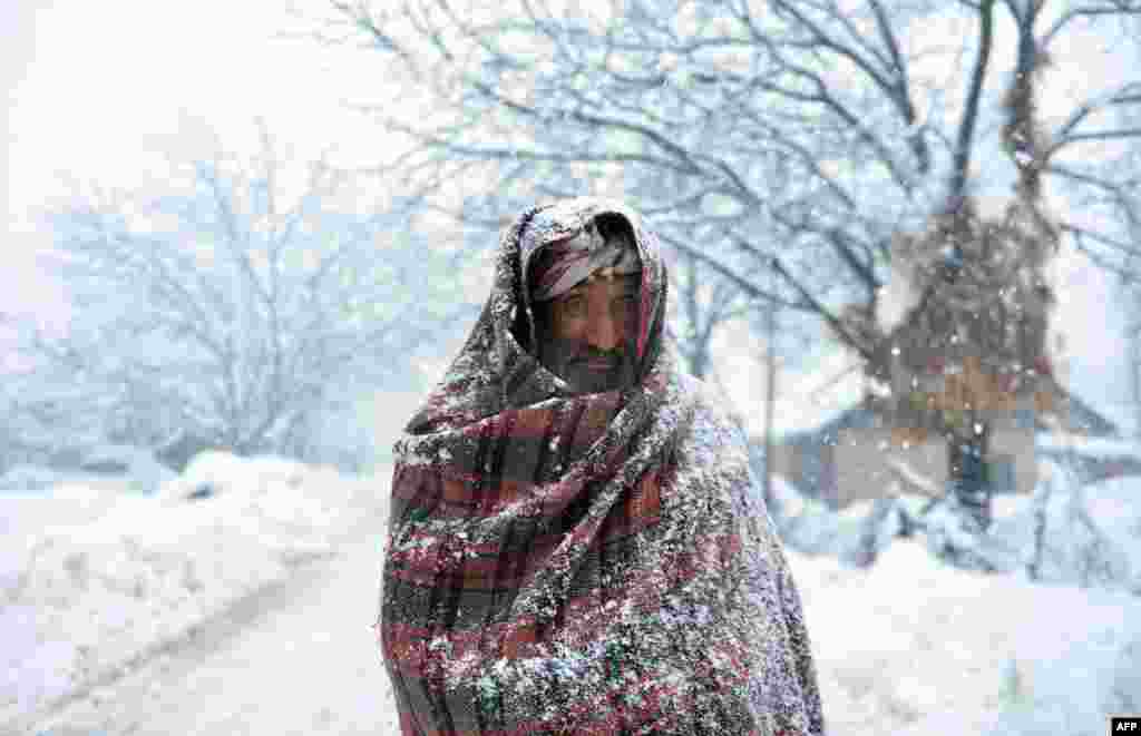 An elderly Kashmiri villager walks through snow in Gund, some 70 kilometers northeast of Srinagar, India.