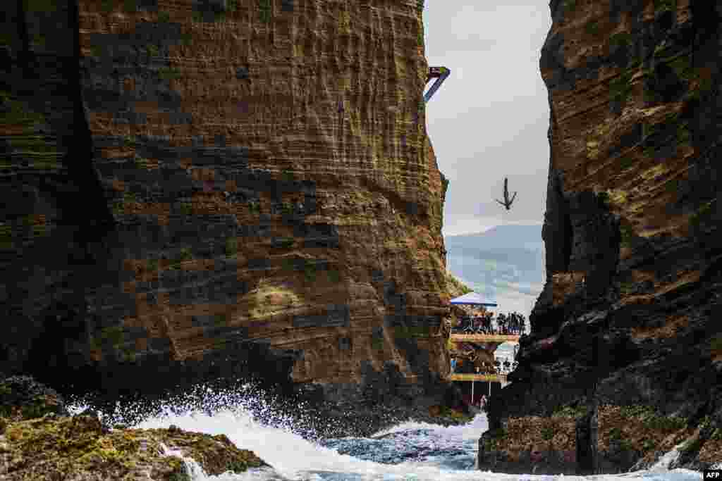 Foto dari Red Bull ini menampilkan Jonathan Paredes dari Meksiko terjun dari papan setinggi 27 meter dalam putaran ke-lima Red Bull Cliff Diving World Series di Islet Franco do Campo, Azores, Portugal.