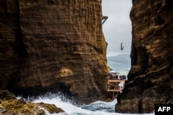 This 2015 photo shows Jonathan Paredes of Mexico diving from the 27 meters in the Red Bull Cliff Diving World Series at Islet Franco do Campo, Azores, Portugal.