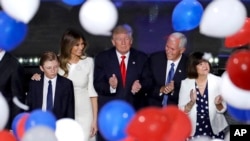Republican presidential candidate Donald Trump, center, watch balloons fall alongside son Barron, from left, wife Melania, Republican vice presidential candidate Gov. Mike Pence of Indiana and Pence's wife Karen after Trump's address to delegates during the final day session of the Republican National Convention in Cleveland, Thursday, July 21, 2016. (AP Photo/Patrick Semansky)