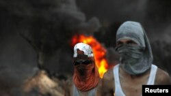 Demonstran Palestina saat mereka bersiap untuk melakukan protes di Tepi Barat yang diduduki Israel, 22 Juni 2021. (Foto: REUTERS/Mohamad Torokman)