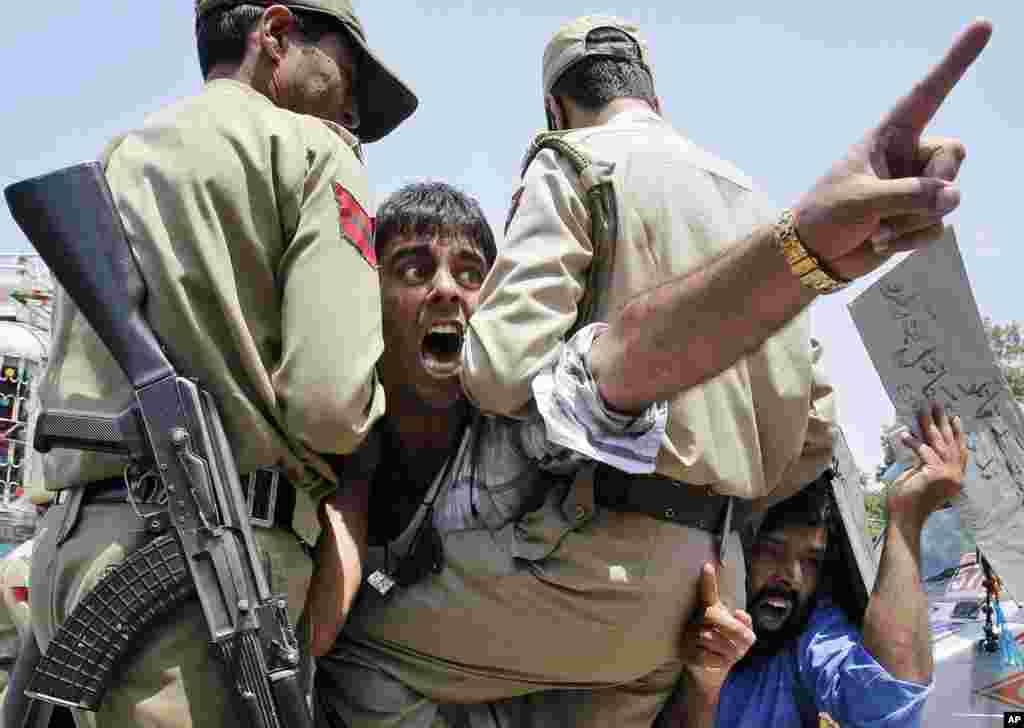 Dua pria Muslim Kashmir meneriakkan slogan anti-Israel saat ditahan oleh polisi Kashmir-India dalam aksi rasa solidaritas bagi warga Jalur Gaza di Srinagar, Kashmir.